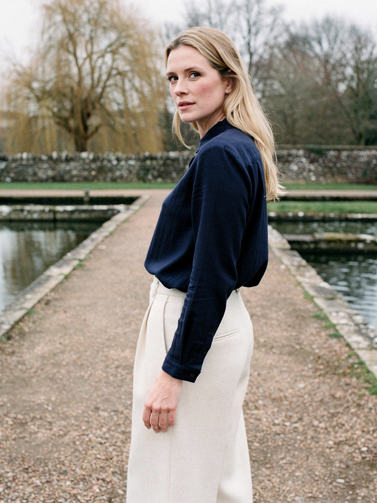 The cotton shirt in Admiralty Navy worn with cream trousers by the water beds