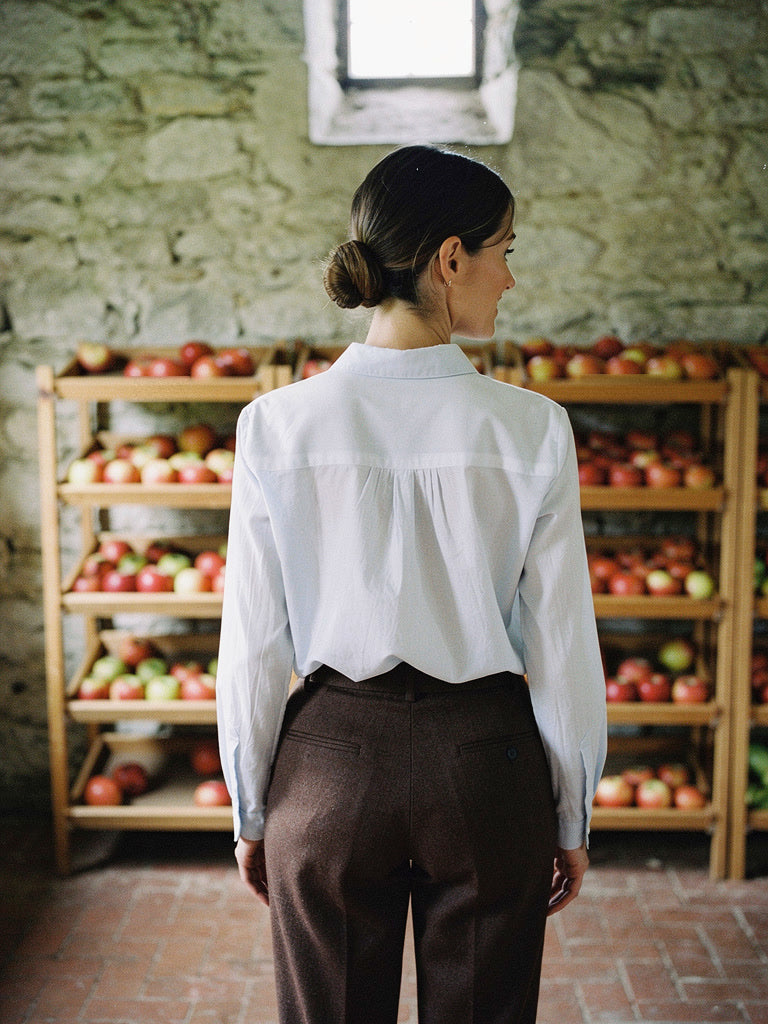 Back of the white shirt showing the gathered yoke seam across the shoulders
