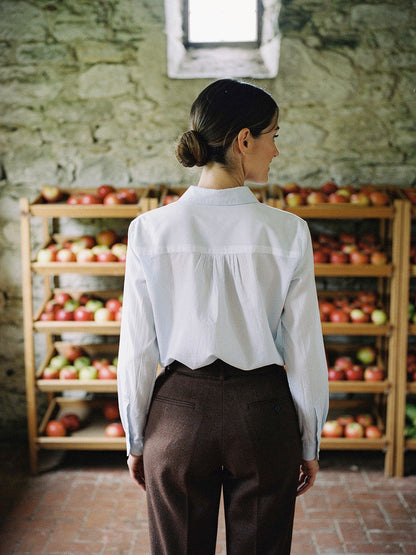 Back of the white shirt showing the gathered yoke seam across the shoulders