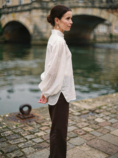 Oversized white shirt in sheer self-stripe voile, side profile by the river