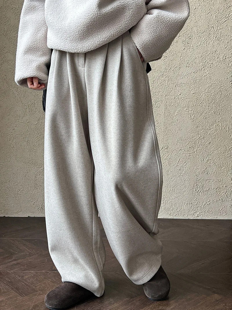 Putty wide-leg trousers worn front on, hands in the slanted side pockets