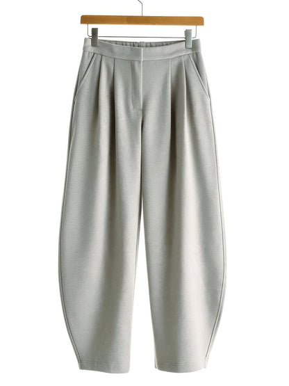 Putty wide-leg trousers with a curved barrel leg on a wooden hanger, front view