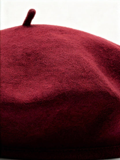 Close up of the milled wool felt and topknot of a womens beret hat