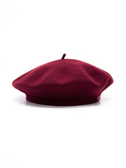 Womens beret hat in Rosehip wine red felt, side view with topknot