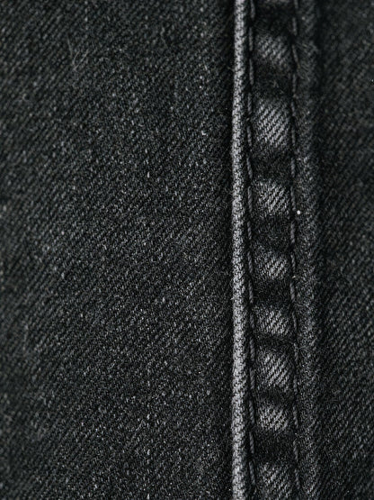 Close-up of the rigid cotton denim and tonal black stitching on the black jeans