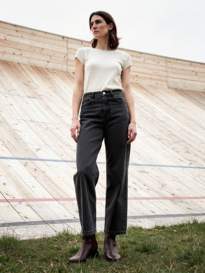 Black jeans in Faded Black worn with a cream knit at an outdoor timber velodrome