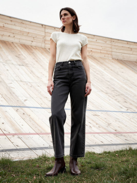 Black jeans in Faded Black worn with a cream knit at an outdoor timber velodrome
