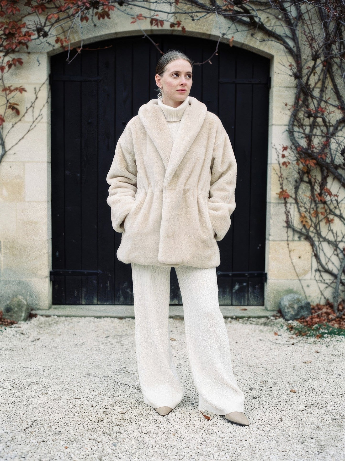 Womens plush faux fur coat with a shawl collar in cream, worn over cream knitwear, front view