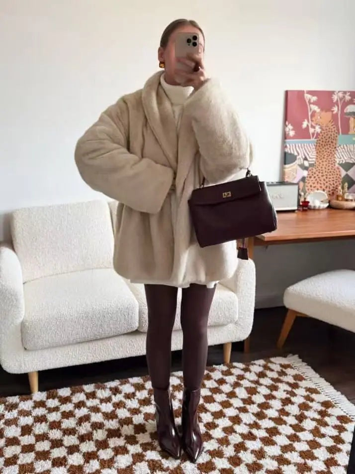 Cream faux fur coat styled with trousers and a shoulder bag