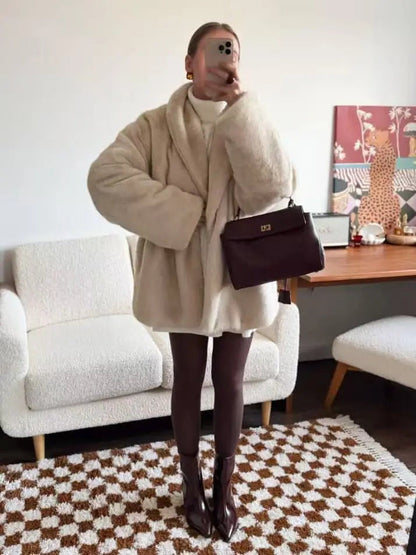 Cream faux fur coat styled with trousers and a shoulder bag
