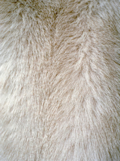 Close-up of the plush faux fur texture of the cream coat