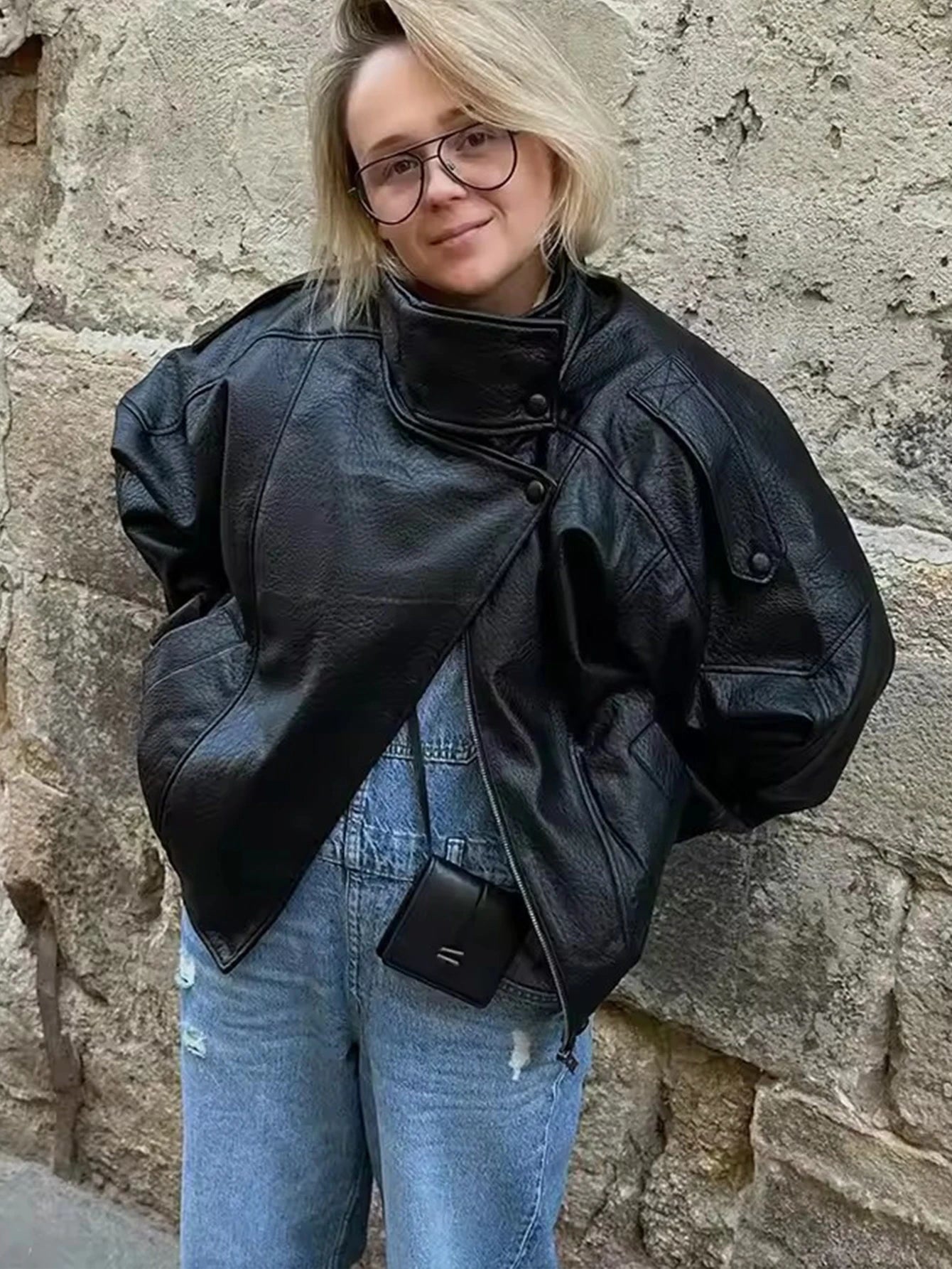 Oversized black faux leather jacket street style look
