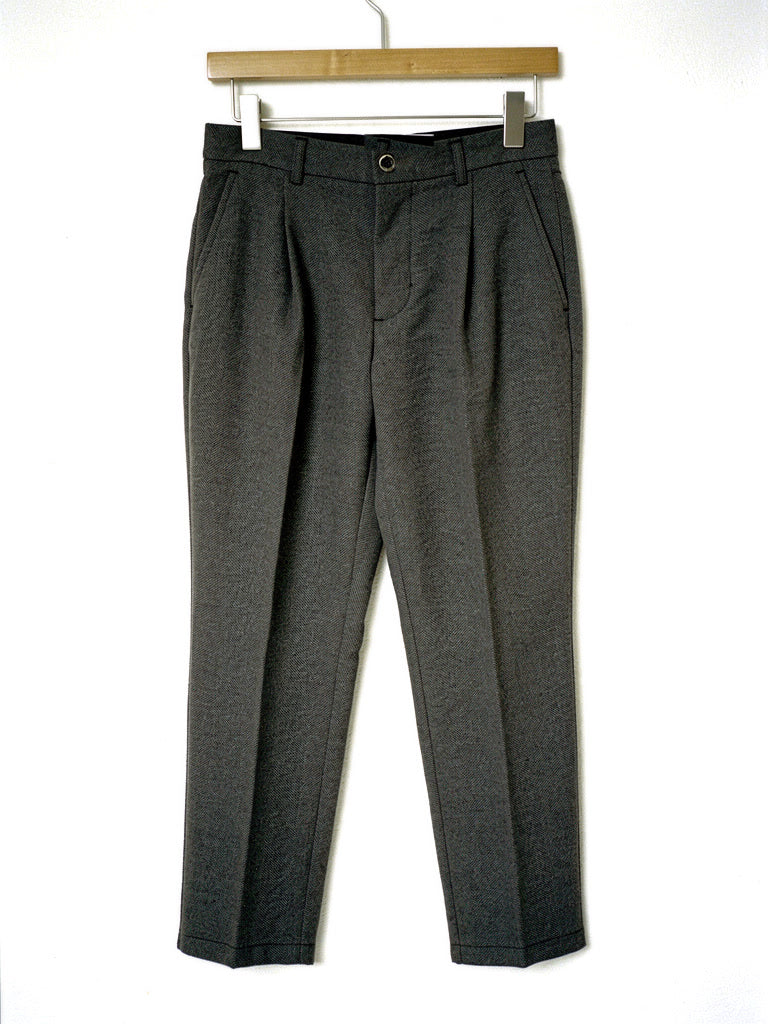 Charcoal herringbone twill high-waisted tapered trousers on a hanger, front view
