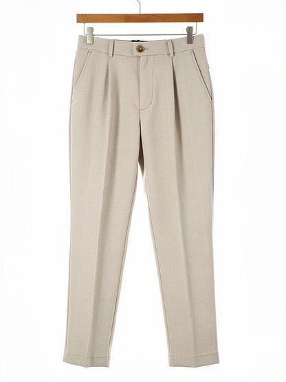 Oat herringbone twill high-waisted tapered trousers on a hanger, front view