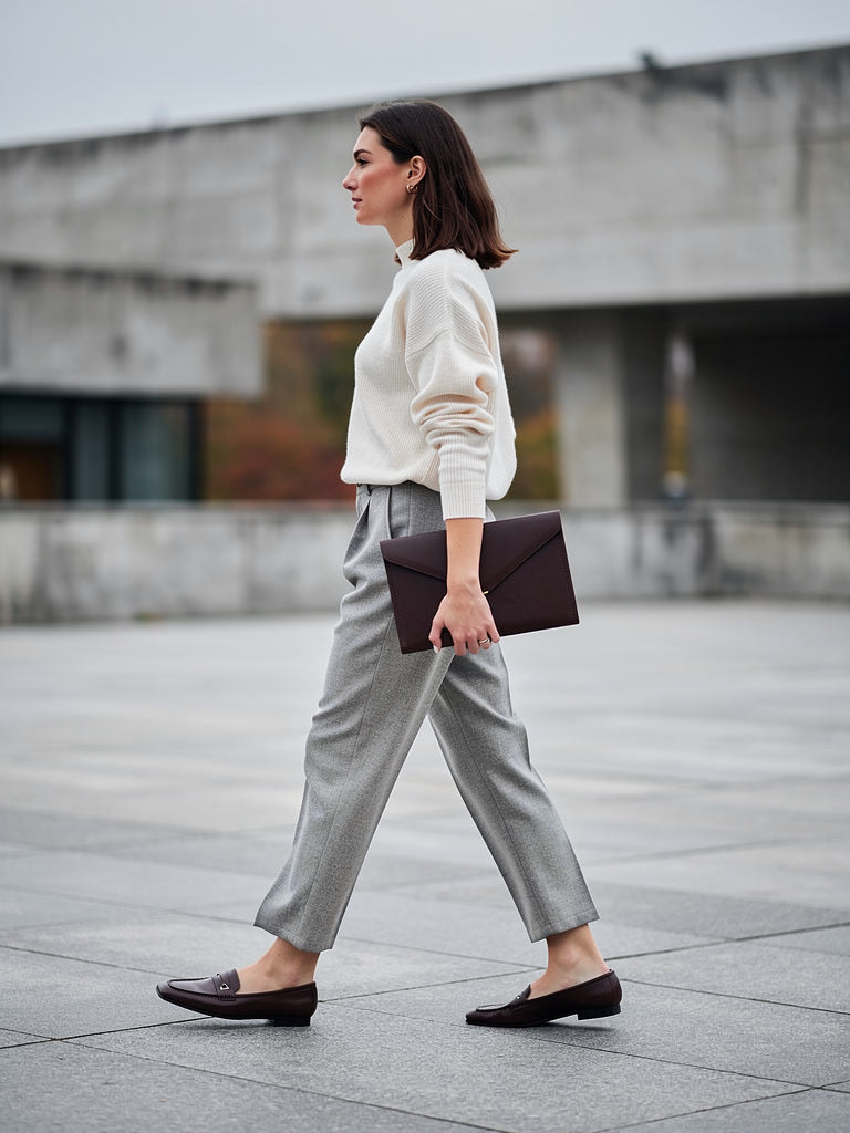 Pewter herringbone tapered trousers worn with a cream jumper and flat loafers