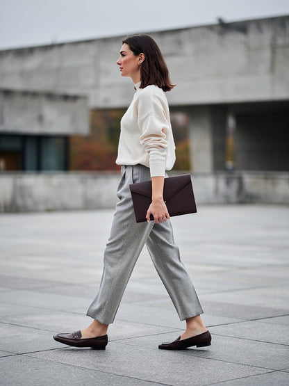 Pewter herringbone tapered trousers worn with a cream jumper and flat loafers