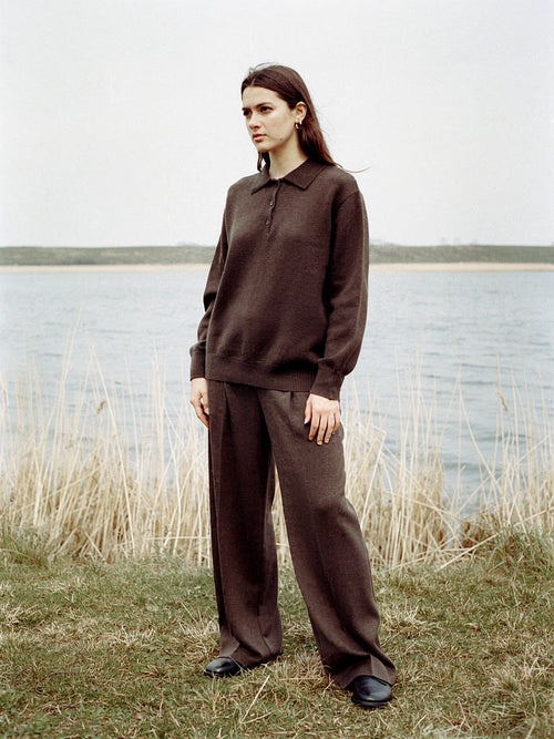 Womens knitted co-ord set in Conker, polo neck jumper and wide leg trousers worn by a lake