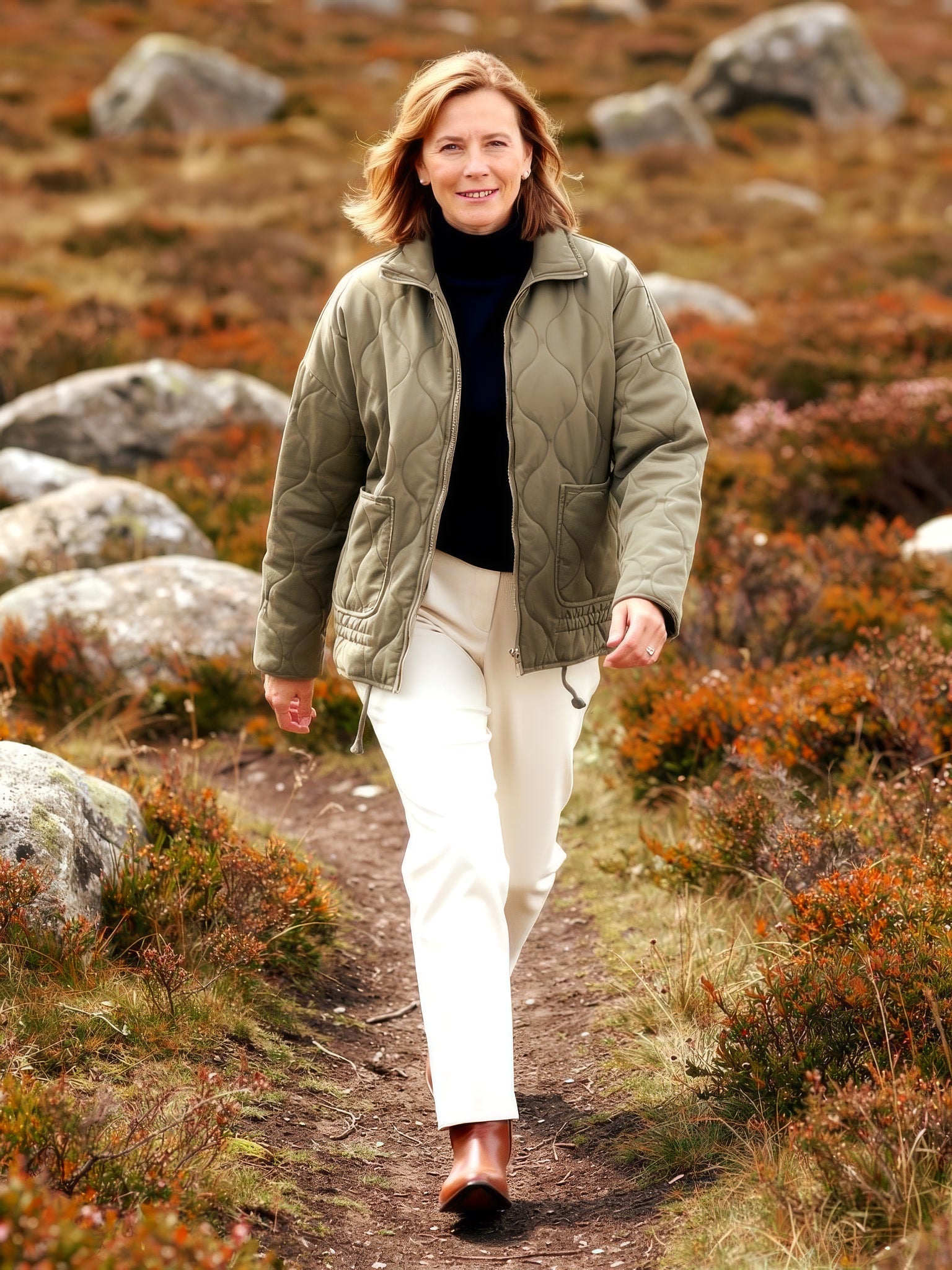 Womens fleece-lined quilted jacket in washed olive, worn on a moorland path