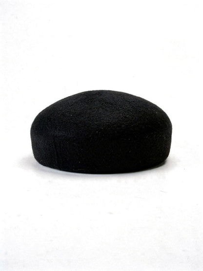 Black wool beret with a seamless felt domed crown, side view