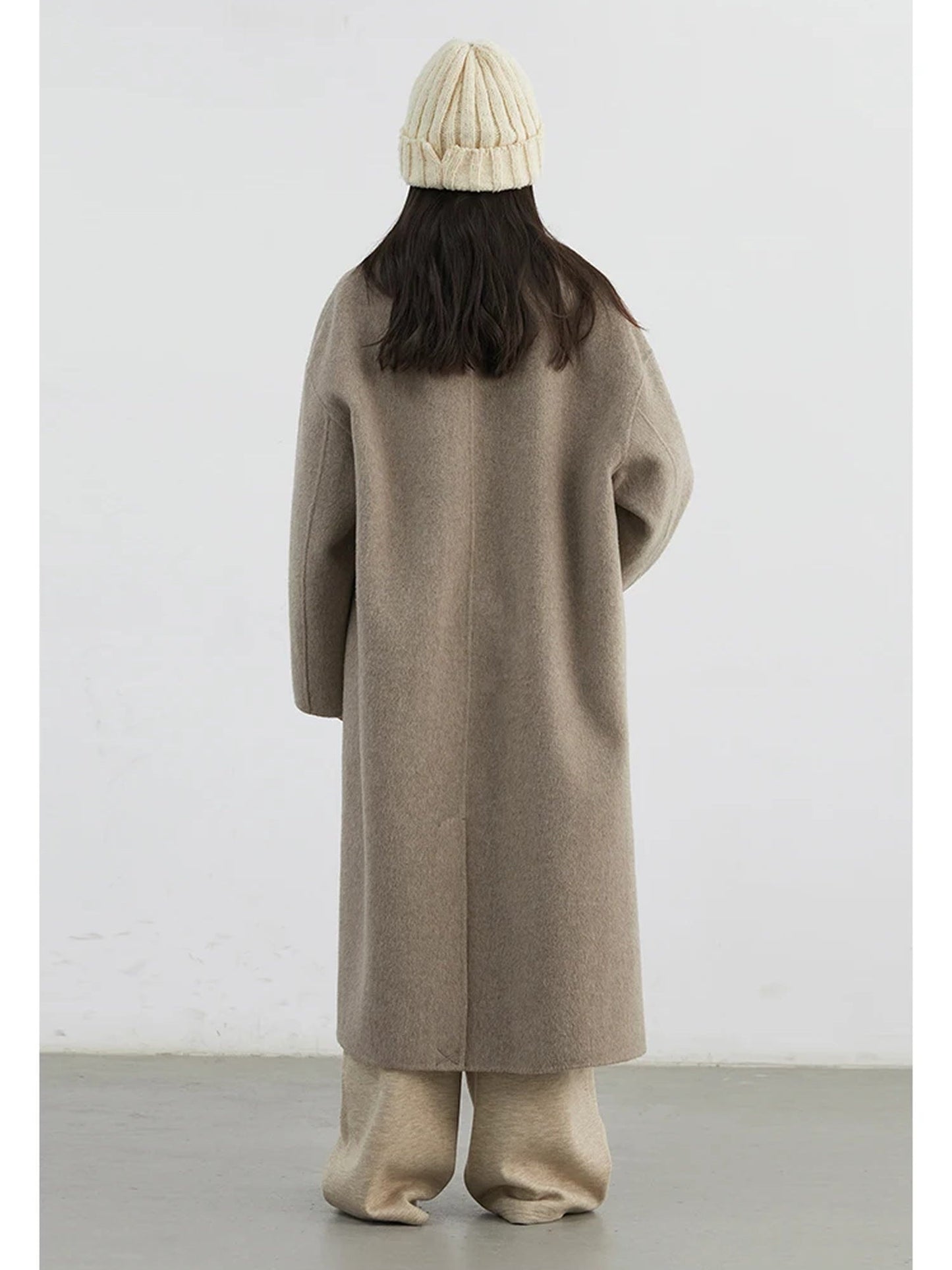 Back of the wool coat in Porcini showing the centre back seam and the short vent at the hem