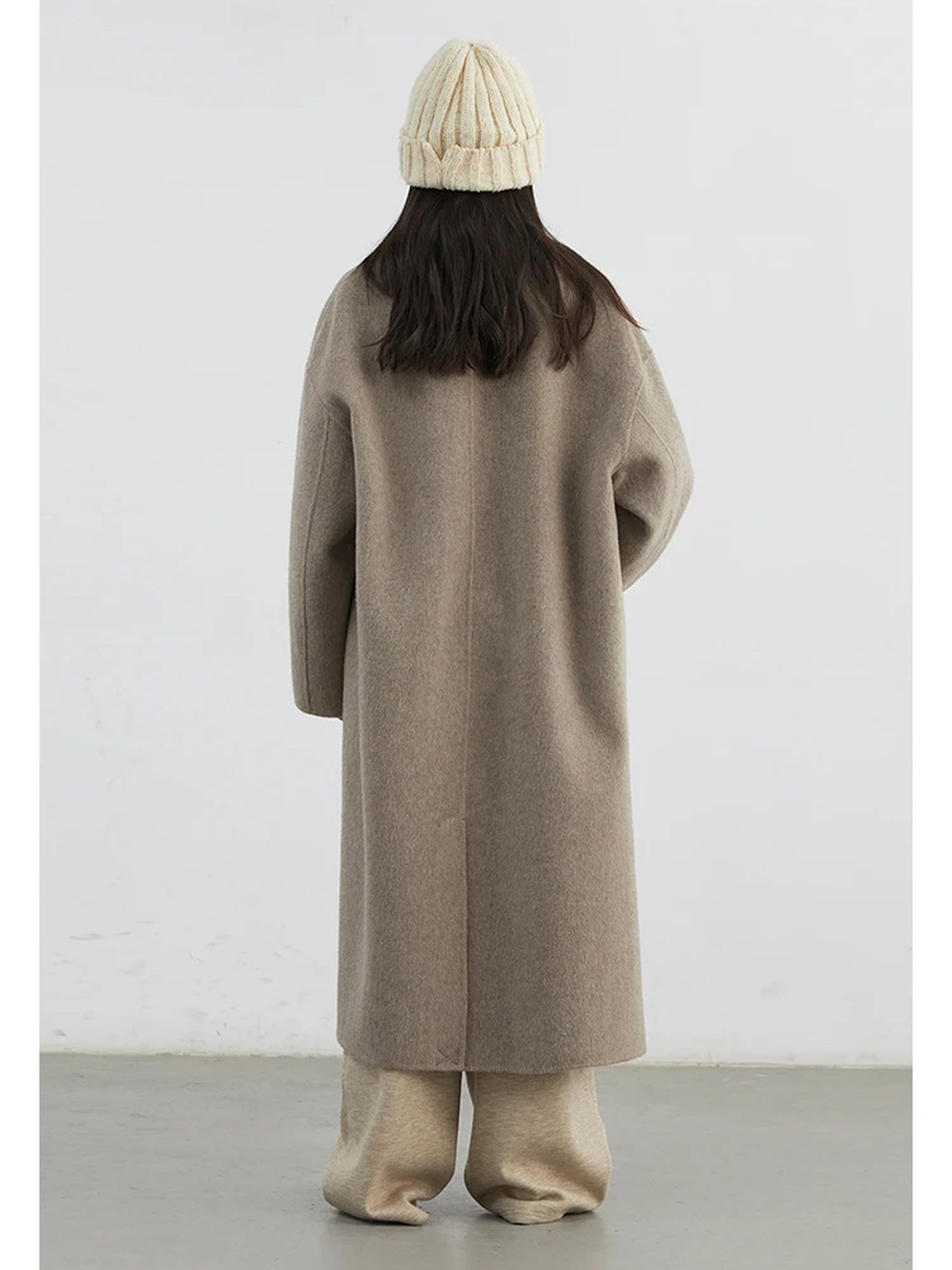 Back of the wool coat in Porcini showing the centre back seam and the short vent at the hem
