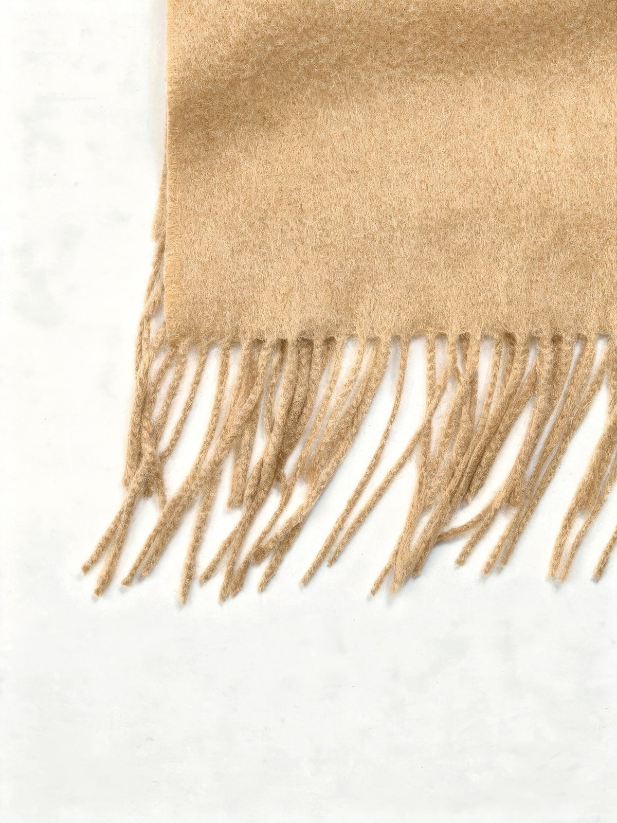 Close up of the brushed wool cloth and the twisted cord fringe of the wool scarf