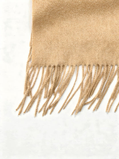 Close up of the brushed wool cloth and the twisted cord fringe of the wool scarf