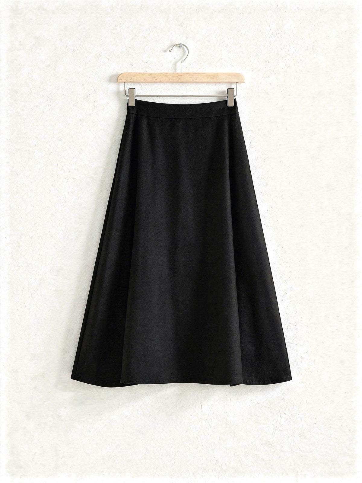 Black wool blend A-line midi skirt on a wooden hanger, Jackdaw, Northleach by Harlbury