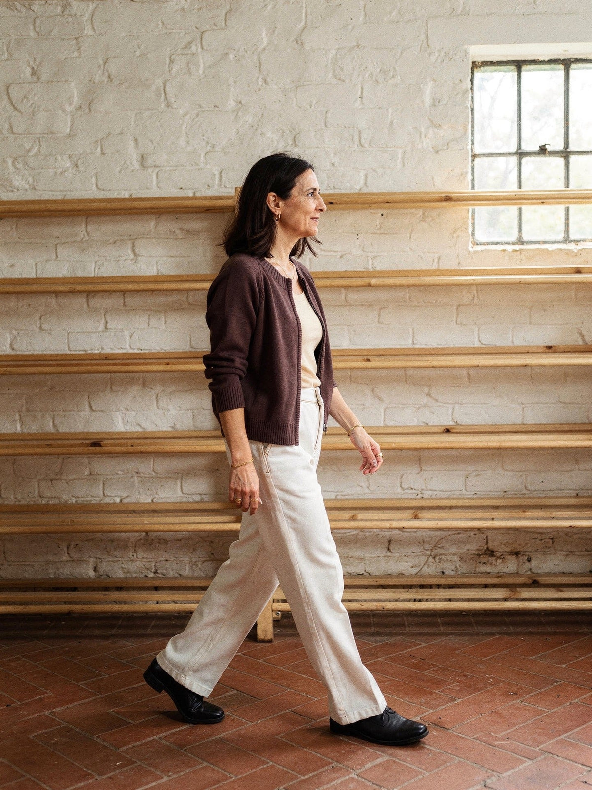 Zip-through cardigan in Cordovan brown seen from the side, raglan sleeve and ribbed hem
